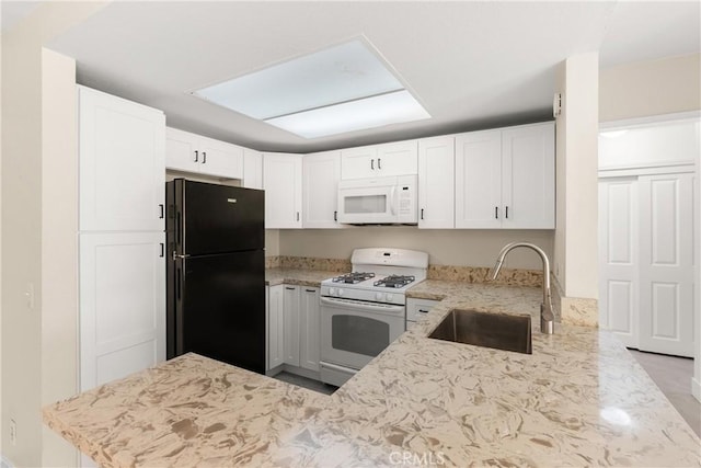 kitchen featuring white cabinetry, sink, light stone countertops, kitchen peninsula, and white appliances