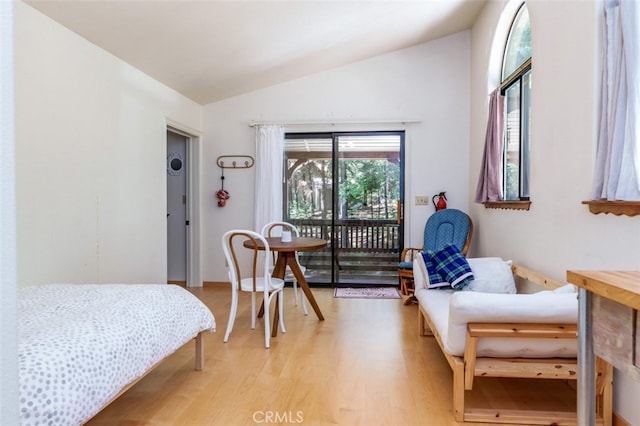 bedroom with light wood-type flooring, access to outside, and vaulted ceiling