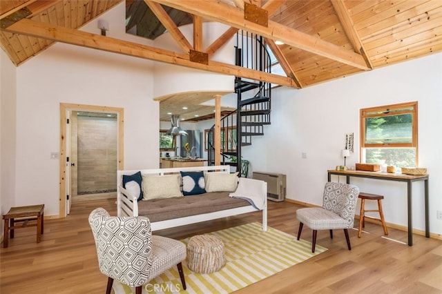 living room featuring beamed ceiling, light hardwood / wood-style floors, and a wealth of natural light