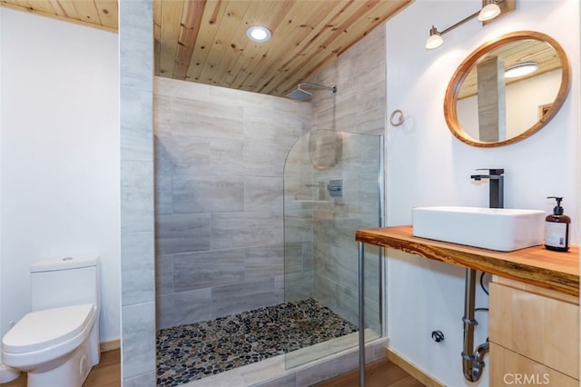 bathroom with wood ceiling, a tile shower, sink, wood-type flooring, and toilet