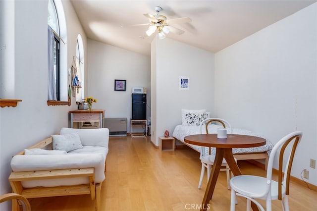 sitting room featuring ceiling fan, light hardwood / wood-style floors, and lofted ceiling