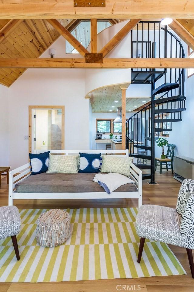 living room featuring hardwood / wood-style floors, beam ceiling, wooden ceiling, and high vaulted ceiling