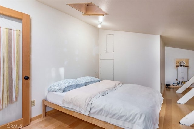 bedroom with hardwood / wood-style floors and lofted ceiling