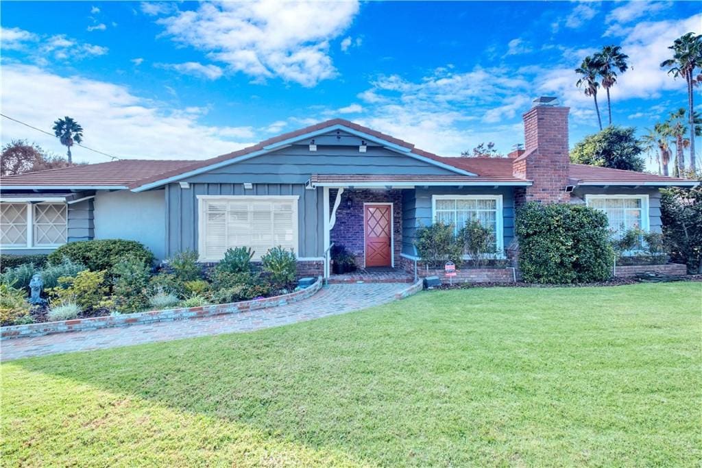 single story home featuring a garage and a front yard