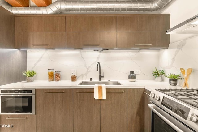 kitchen with backsplash, sink, stainless steel appliances, and extractor fan