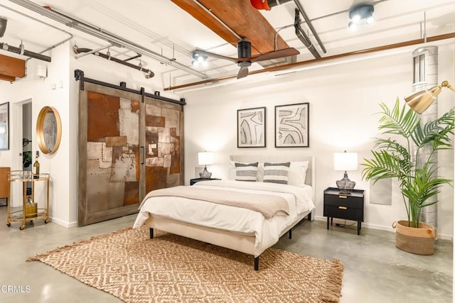 bedroom with a barn door and concrete flooring