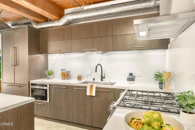 kitchen featuring backsplash, oven, sink, dark brown cabinets, and light tile patterned flooring