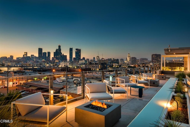 patio terrace at dusk featuring an outdoor fire pit