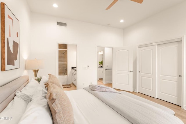 bedroom featuring ensuite bath, ceiling fan, a closet, and light hardwood / wood-style floors