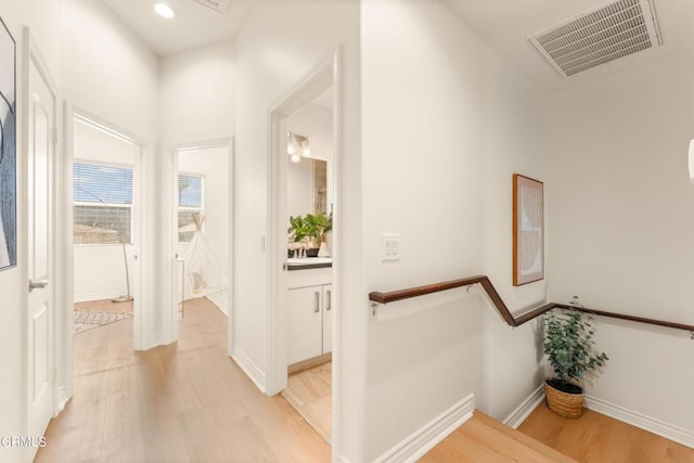 hallway featuring a towering ceiling and light wood-type flooring