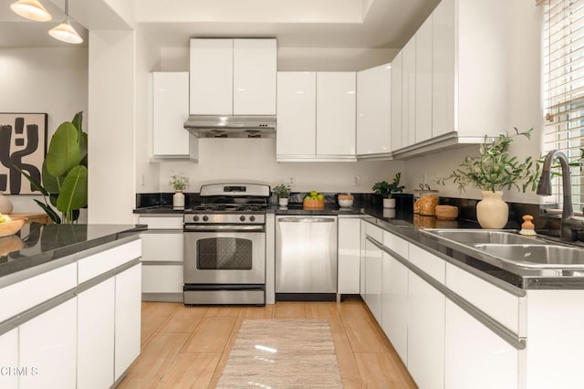 kitchen with white cabinets, appliances with stainless steel finishes, pendant lighting, and sink