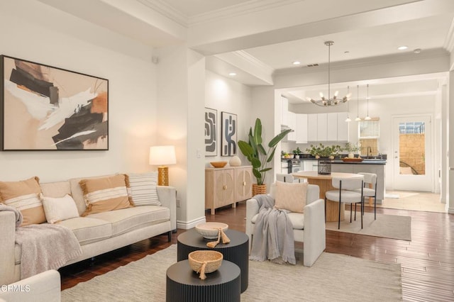 living room with hardwood / wood-style floors, crown molding, and an inviting chandelier