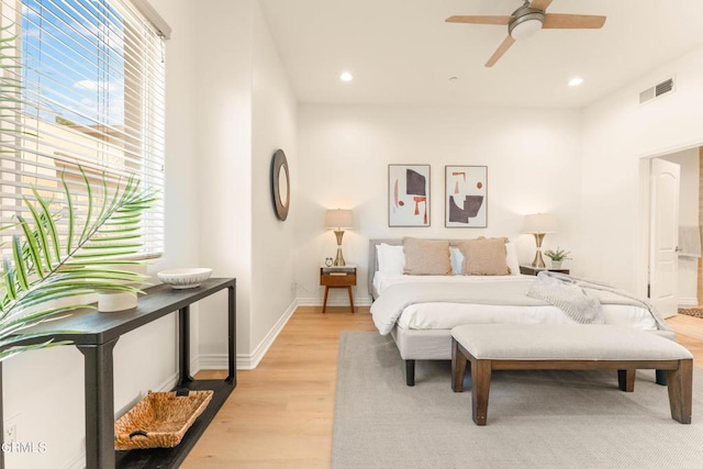 bedroom with ceiling fan, light wood-type flooring, and multiple windows