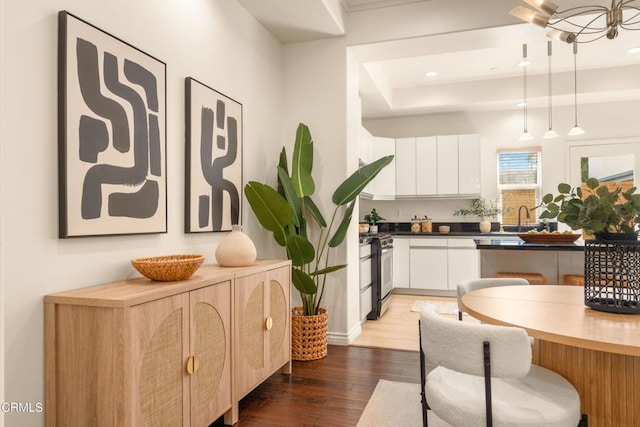 kitchen with range with gas cooktop, sink, decorative light fixtures, white cabinets, and dark hardwood / wood-style floors