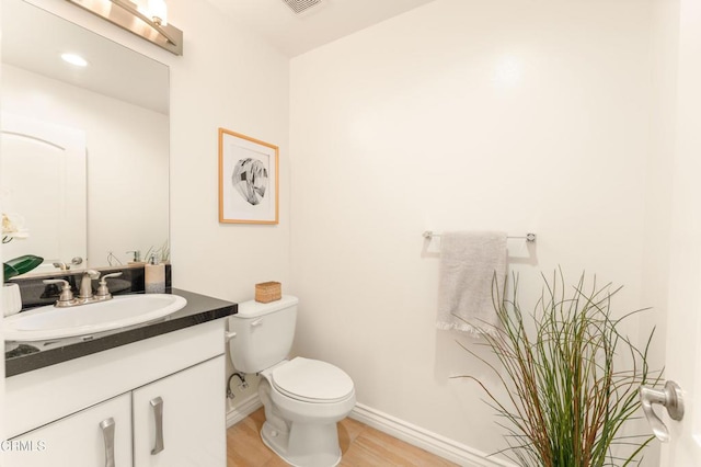 bathroom featuring hardwood / wood-style floors, vanity, and toilet