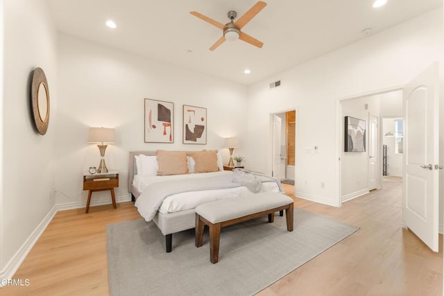 bedroom featuring ceiling fan, ensuite bath, and light hardwood / wood-style flooring