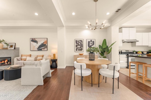 dining space featuring crown molding, hardwood / wood-style floors, and an inviting chandelier