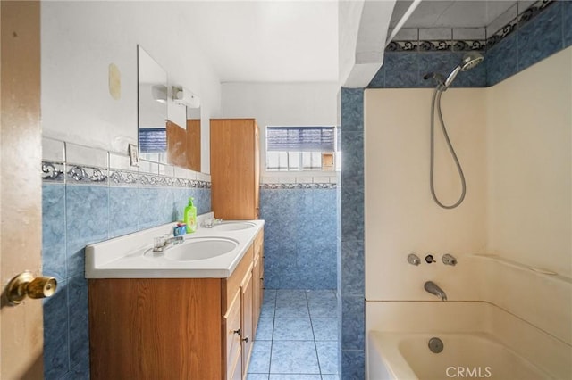 bathroom with vanity, shower / bath combination, tile patterned flooring, and tile walls