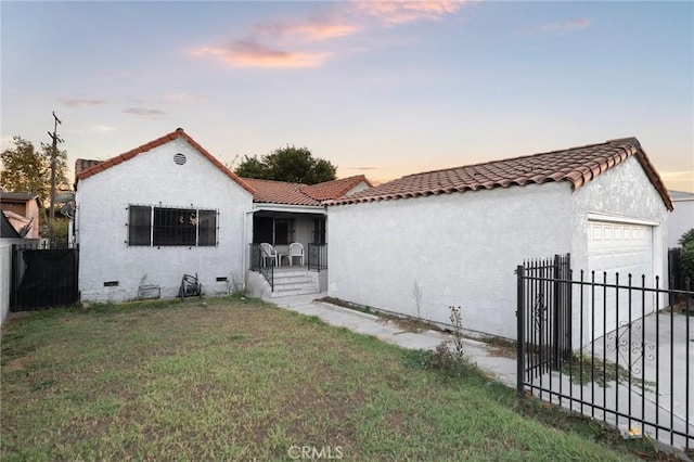 mediterranean / spanish home featuring a yard and a garage