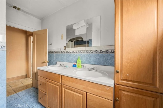 bathroom with tile patterned flooring, vanity, backsplash, and walk in shower