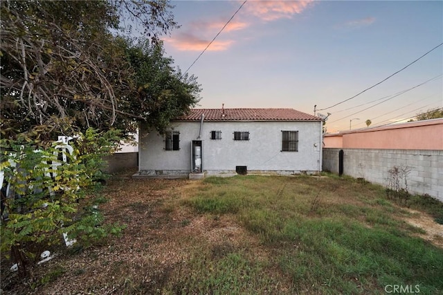 back house at dusk with a yard