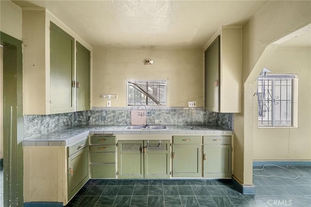 kitchen with tile countertops, sink, and backsplash