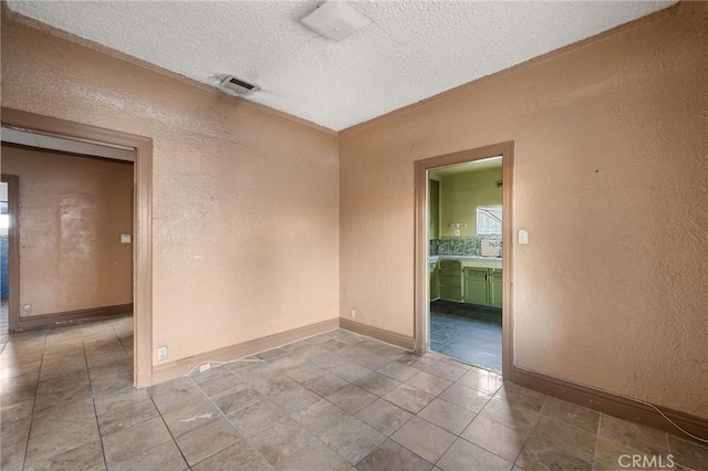 unfurnished room with a textured ceiling