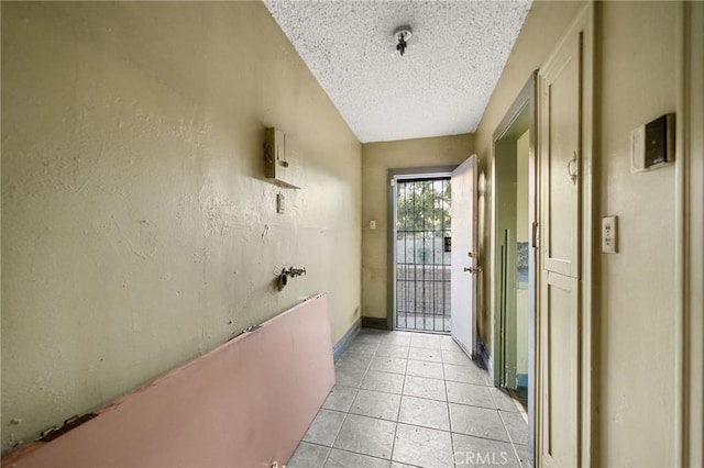 entryway featuring light tile patterned flooring and a textured ceiling