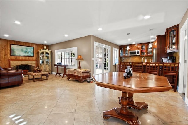 tiled dining space with french doors and a brick fireplace