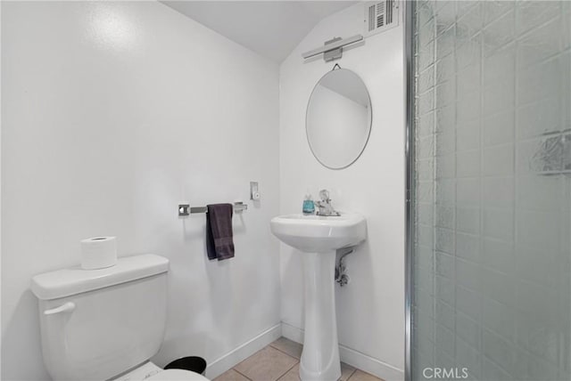 bathroom with toilet, tile patterned floors, and vaulted ceiling