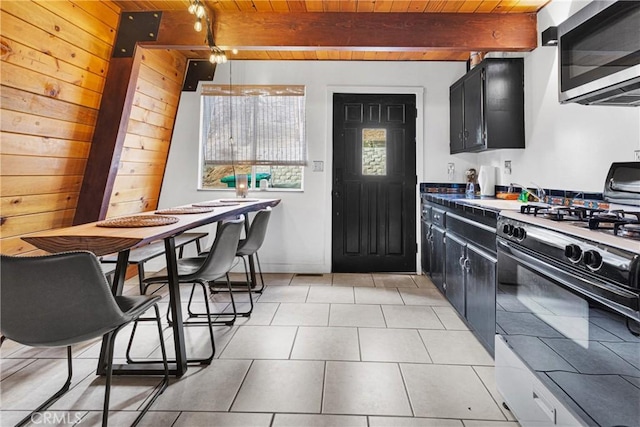 kitchen with beamed ceiling, light tile patterned floors, range with gas cooktop, and wood ceiling