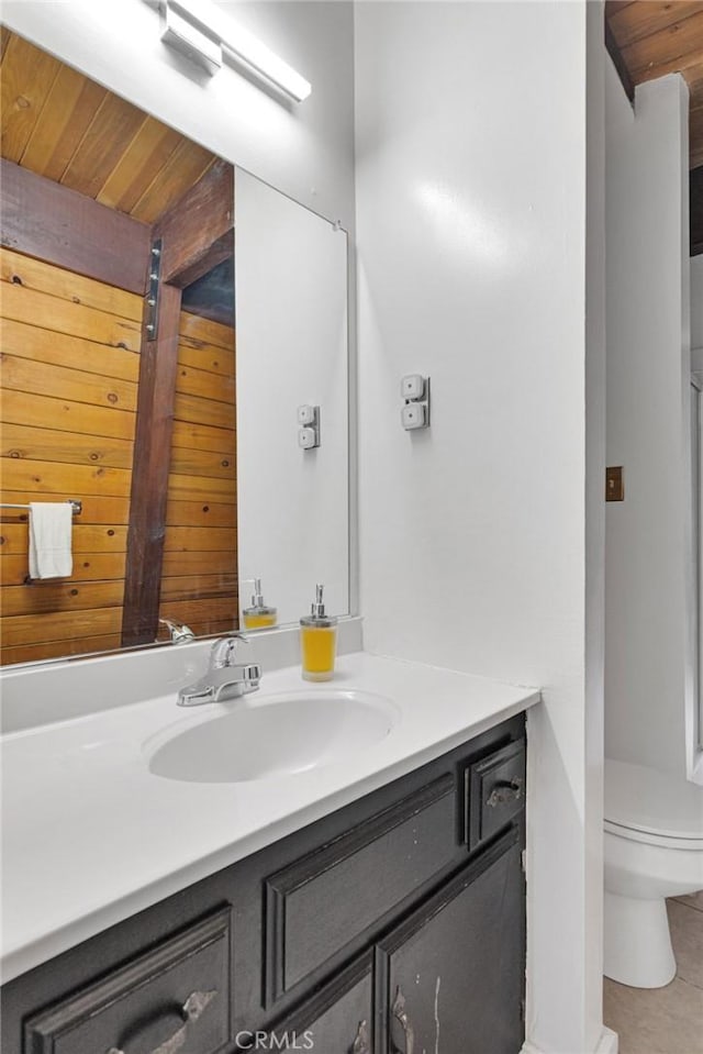 bathroom with vanity, wooden ceiling, tile patterned floors, wooden walls, and toilet