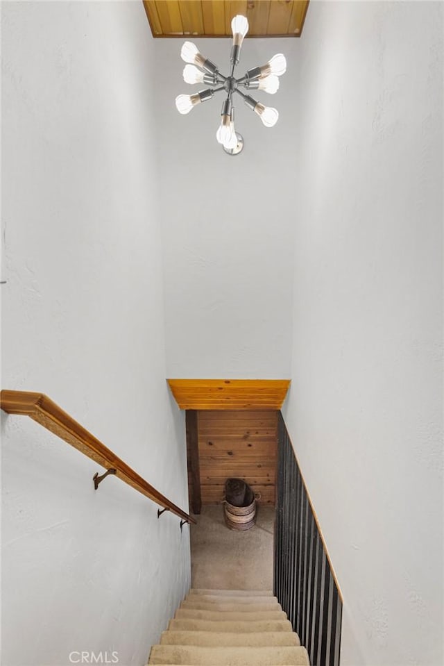 staircase with wood ceiling and a notable chandelier