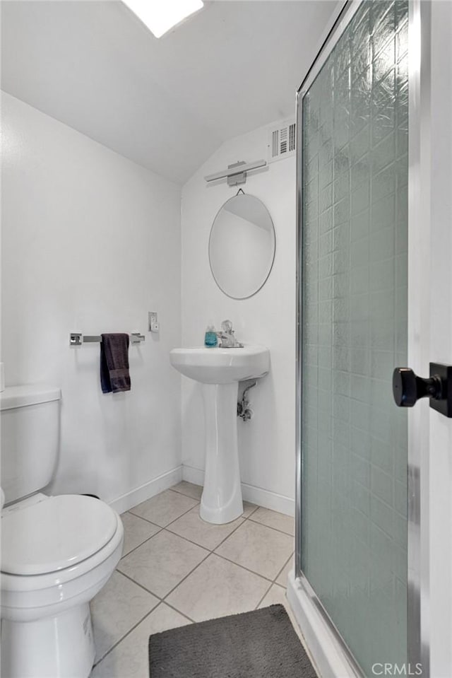 bathroom featuring tile patterned floors, lofted ceiling, toilet, and a shower with door