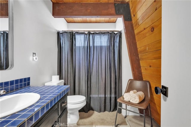 bathroom featuring beamed ceiling, tile patterned floors, toilet, vanity, and wood ceiling