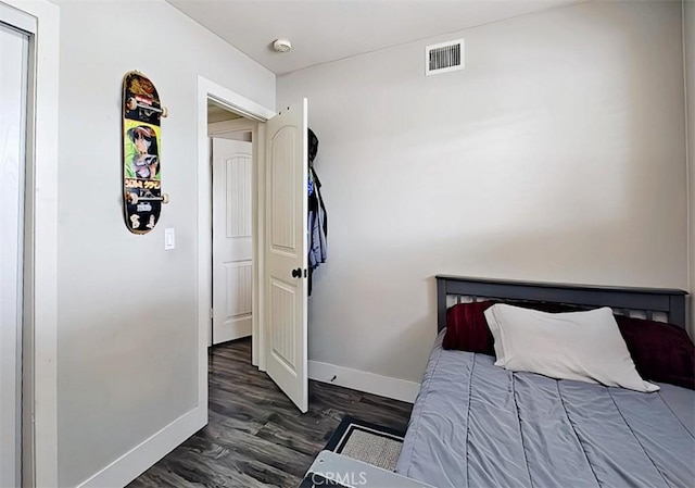 bedroom with dark wood-type flooring