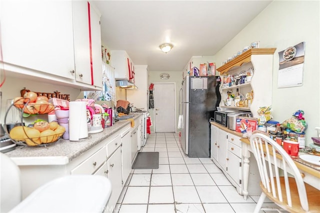 kitchen with light tile patterned floors, stainless steel appliances, and white cabinetry