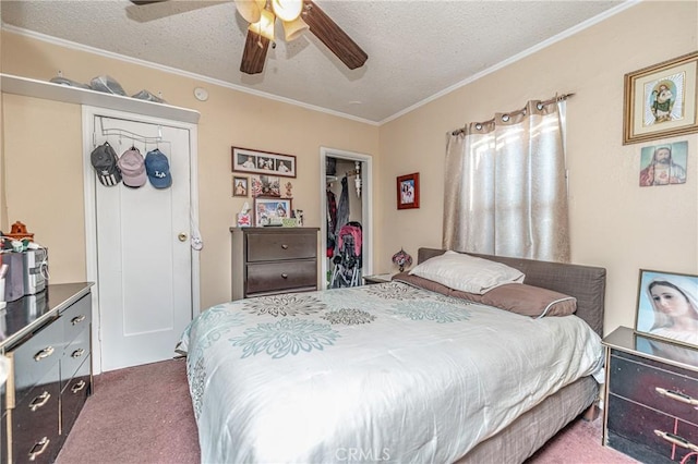 carpeted bedroom with a textured ceiling, a closet, ceiling fan, and ornamental molding