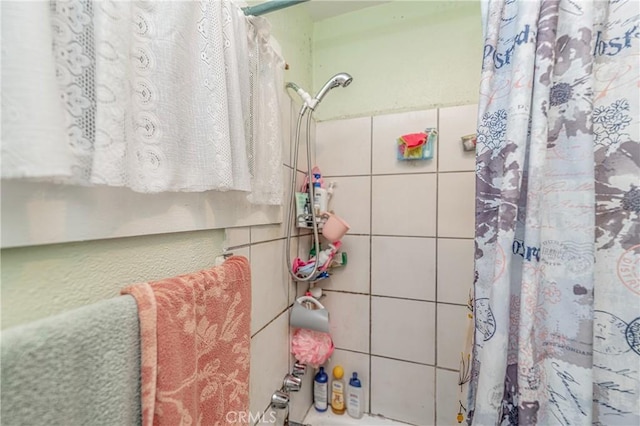 bathroom featuring tile walls and walk in shower