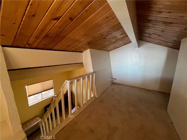 additional living space with lofted ceiling with beams, wood ceiling, and light carpet