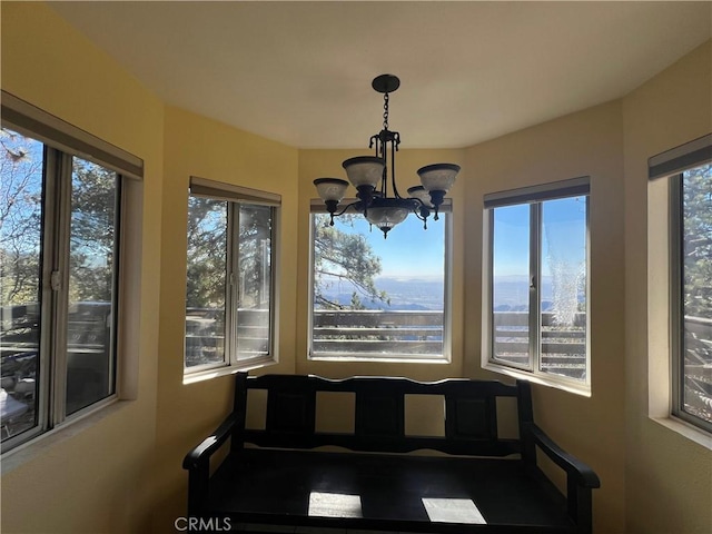 unfurnished sunroom featuring a healthy amount of sunlight and a chandelier