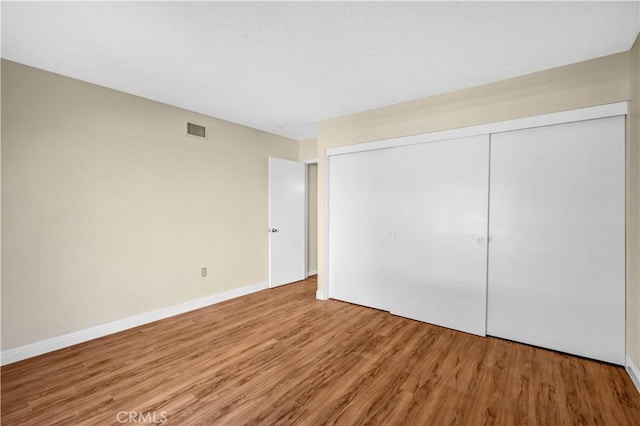 unfurnished bedroom featuring a closet and hardwood / wood-style floors