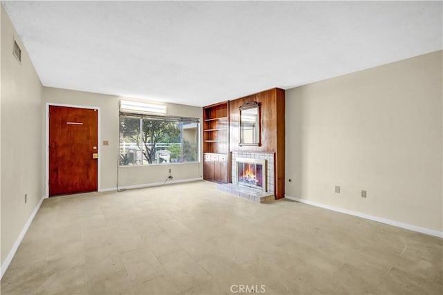 unfurnished living room featuring a tile fireplace