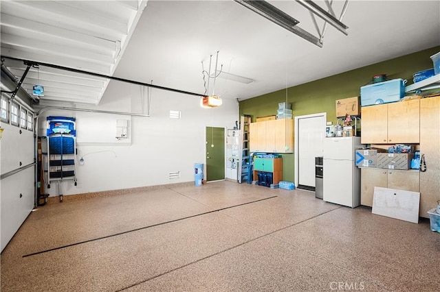 garage with a garage door opener and white refrigerator