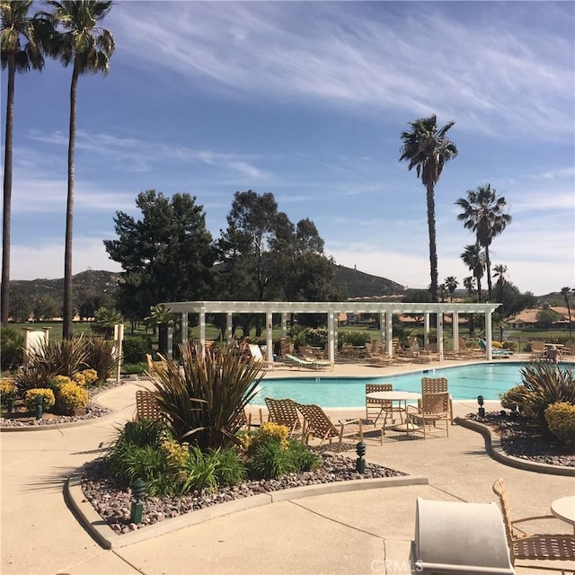 view of swimming pool featuring a patio area and a mountain view