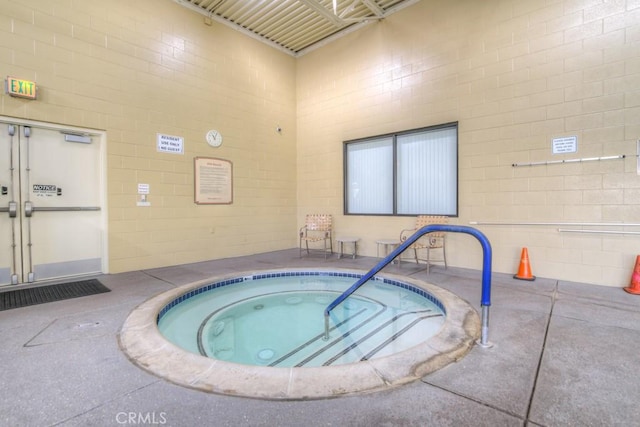 view of swimming pool with an indoor hot tub and a patio