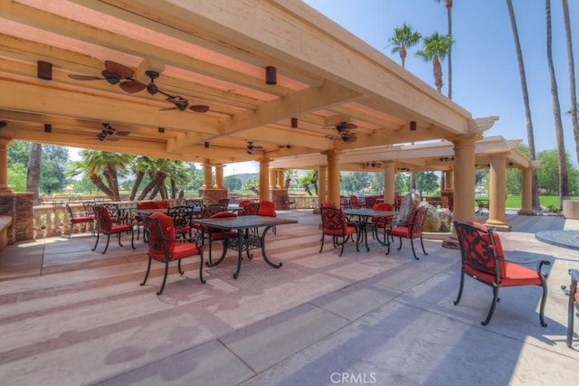 view of patio / terrace featuring an outdoor stone fireplace, ceiling fan, and a gazebo