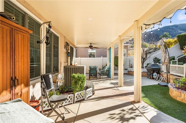 view of patio / terrace with central air condition unit, a grill, a mountain view, and a porch