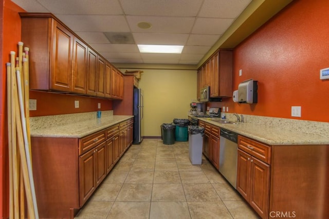 2028 Melbourne Cir, Banning, CA 92220 - kitchen with appliances with stainless steel finishes, a sink, a paneled ceiling, light tile patterned flooring, and light stone counters