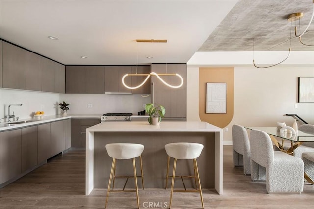 kitchen with gray cabinetry, sink, a center island, and light wood-type flooring